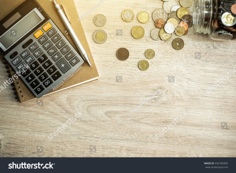 calculatrice et pieces de monnaie sur une table