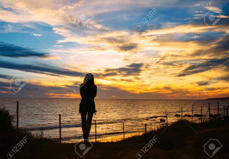 femme pensive devant un coucher de soleil