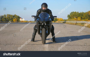 motard avec casque devant une moto