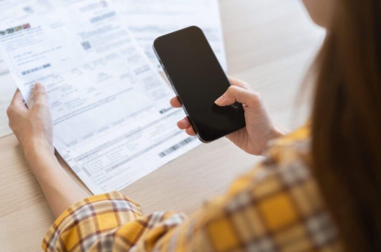 personne au telephone avec des documents deco energie