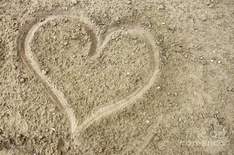 un coeur dessine dans le sable