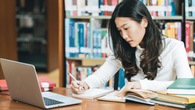 un eleve revisant avec des livres ouverts